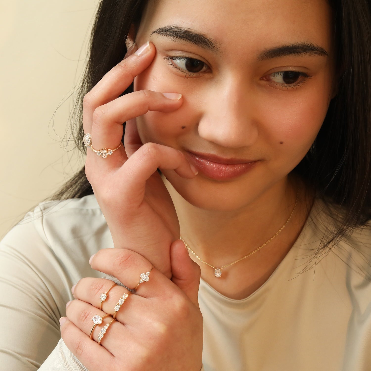 Model draagt 14 karaat gouden ringen en een diamant ketting voor een elegante, tijdloze look